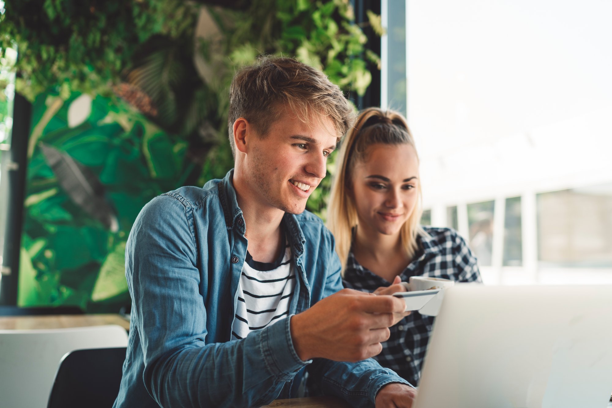 side-view-young-man-using-mobile-phone-while-sitting-chair
